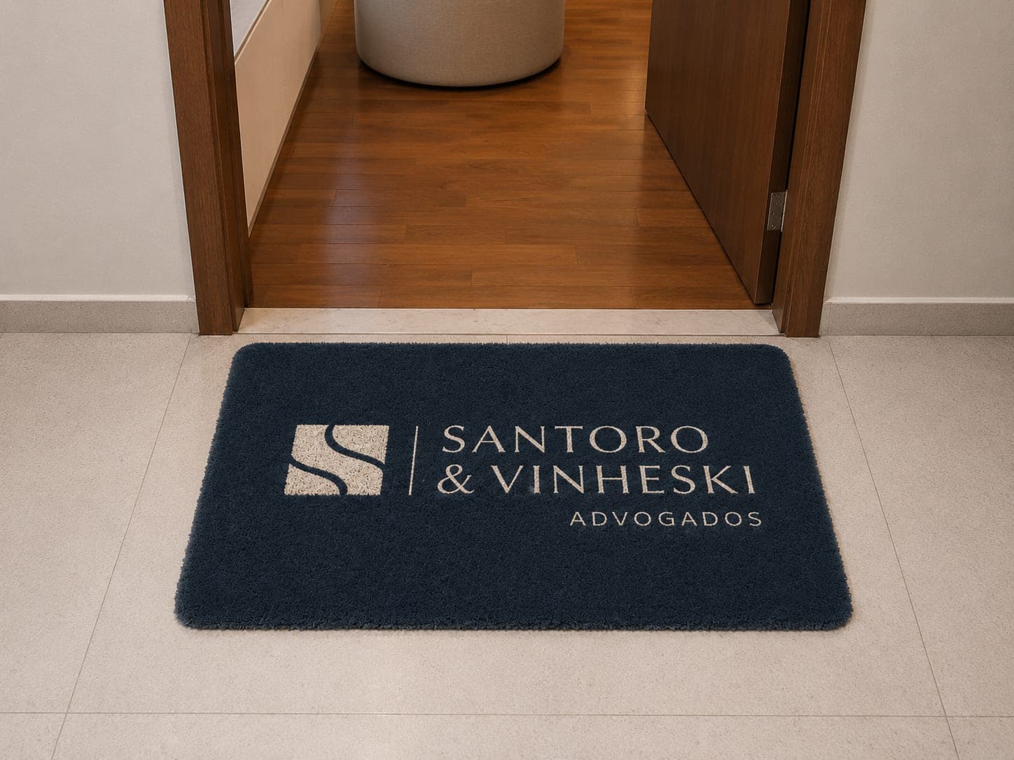 Entrada do escritório Santoro & Vinheski, com o logotipo aplicado no tapete